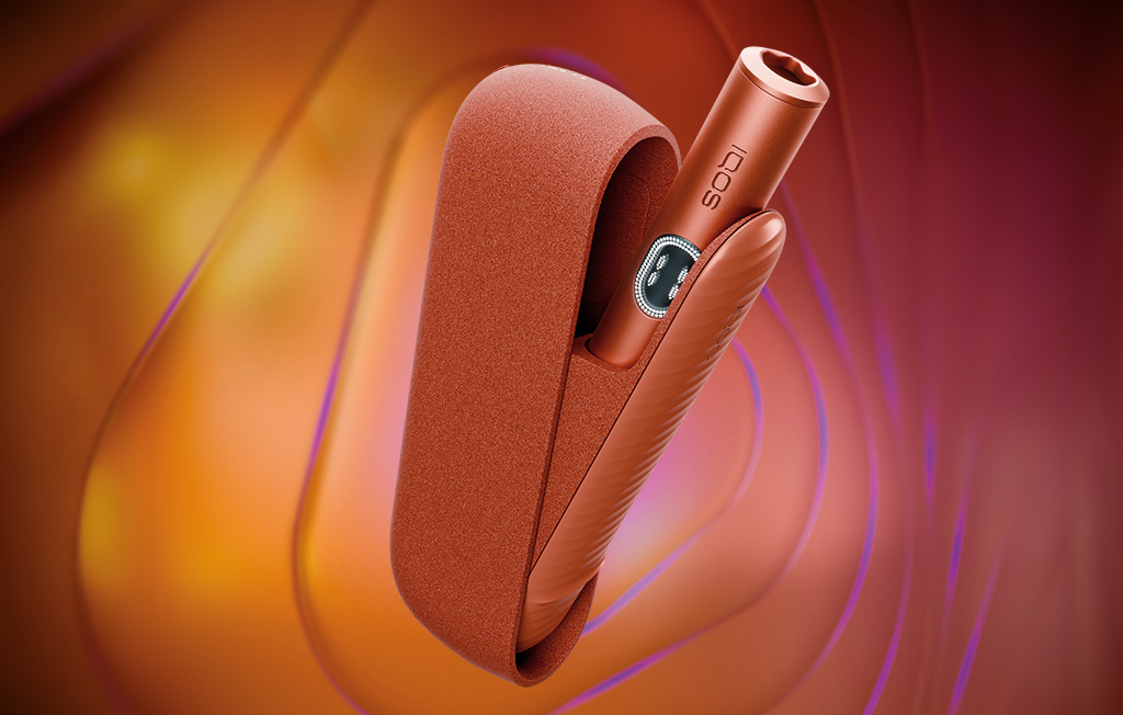 Equipamento IQOS ILUMA i na cor Terracota, com o ecrã tátil ligado, orientado para a direita sobre fundo com efeito tridimensional concêntrico.